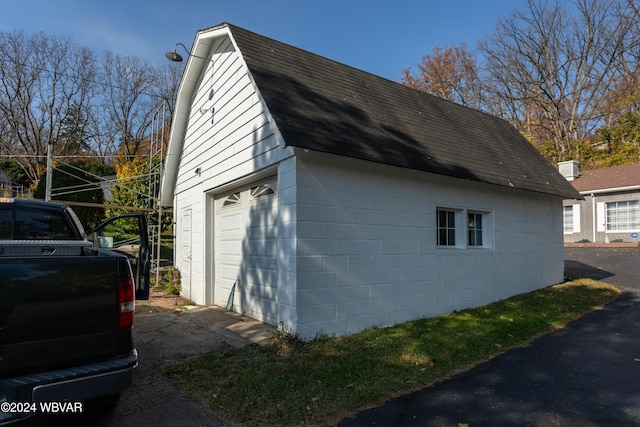 view of side of property with a garage and an outbuilding