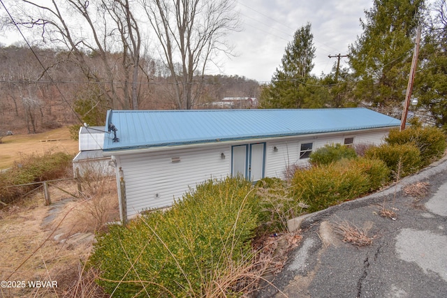 view of front of house featuring metal roof and fence