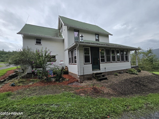 rear view of property with a sunroom