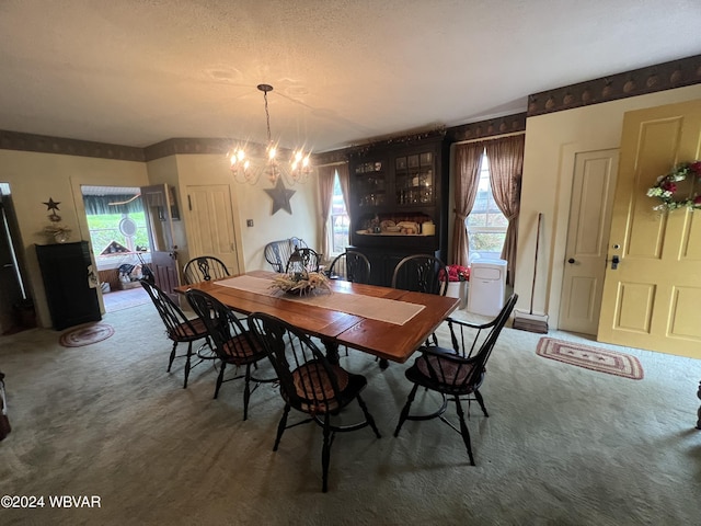 dining area with a chandelier, plenty of natural light, and dark carpet