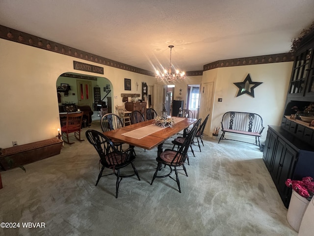 carpeted dining area featuring a textured ceiling and an inviting chandelier