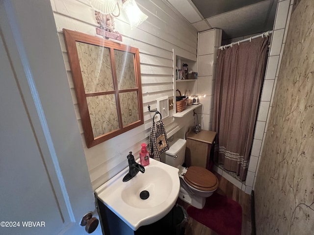 bathroom featuring toilet, sink, and a shower with shower curtain