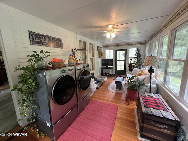 washroom with separate washer and dryer, ceiling fan, light hardwood / wood-style flooring, and wood walls