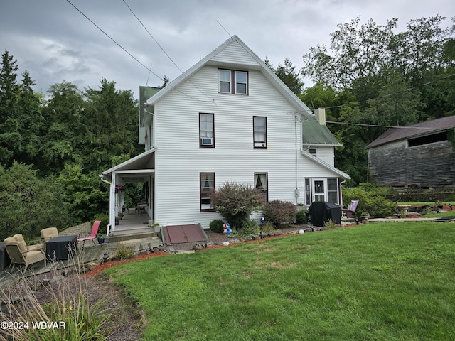 rear view of house featuring a yard