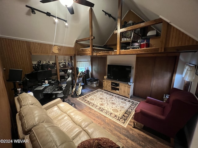 living room with wooden walls, ceiling fan, wood-type flooring, and high vaulted ceiling