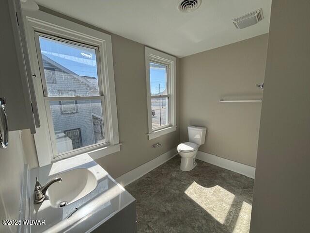 bathroom with vanity, toilet, baseboards, and visible vents