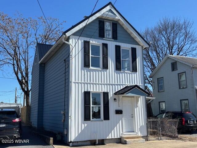 view of front facade with board and batten siding and fence