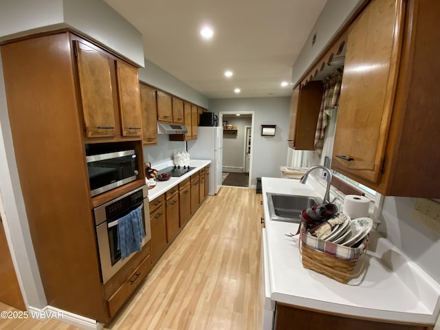 699 James St, Lock Haven, PA 17745 - kitchen featuring stainless steel appliances, a sink, under cabinet range hood, recessed lighting, and brown cabinetry