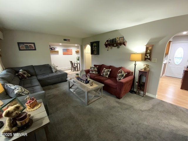 699 James St, Lock Haven, PA 17745 - living room featuring arched walkways, carpet floors, and baseboards