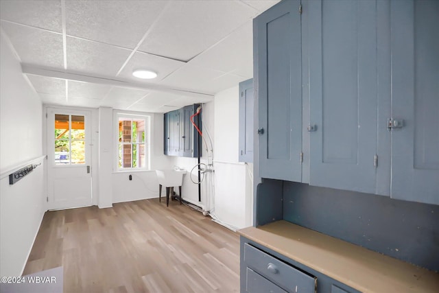 interior space featuring a drop ceiling and light wood-type flooring