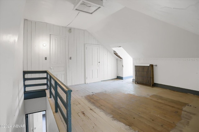 additional living space with hardwood / wood-style flooring and lofted ceiling