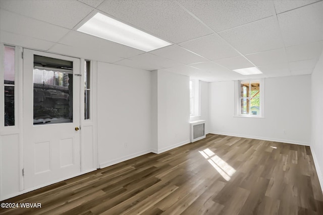 spare room featuring dark hardwood / wood-style floors and a drop ceiling