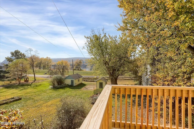 wooden deck featuring a storage shed and a yard