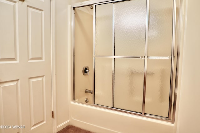 bathroom featuring bath / shower combo with glass door