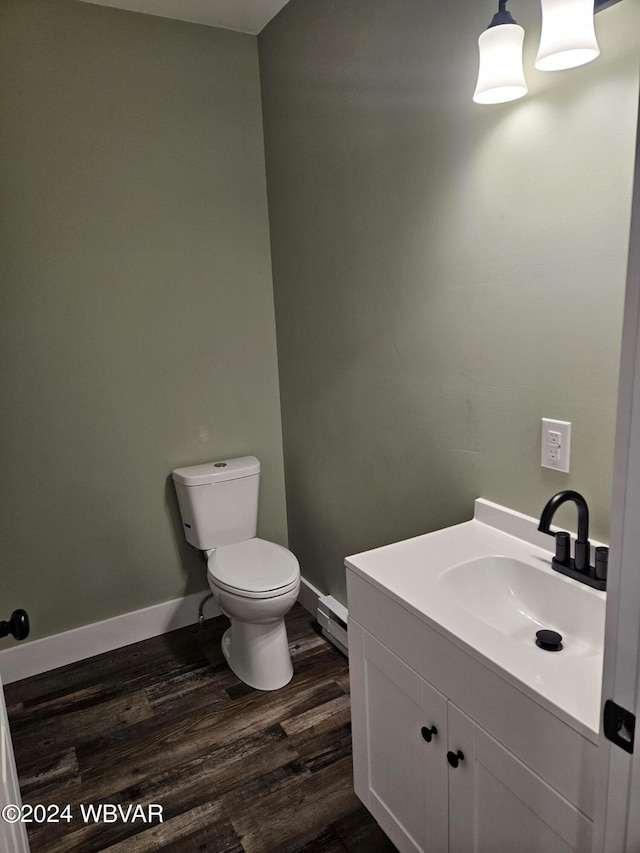 bathroom with baseboard heating, hardwood / wood-style floors, vanity, and toilet