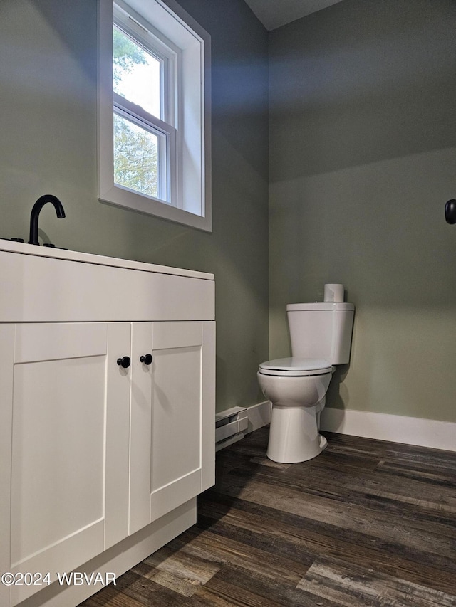 bathroom featuring hardwood / wood-style flooring, toilet, and baseboard heating