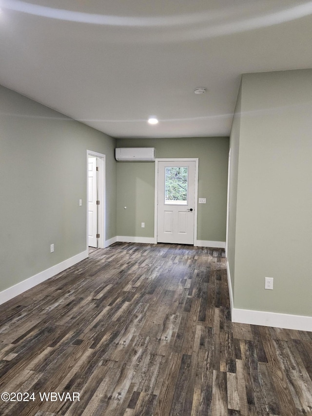 foyer with an AC wall unit and dark hardwood / wood-style floors