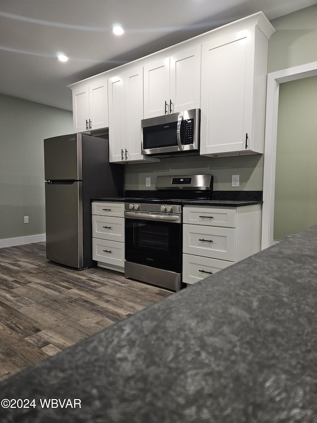 kitchen featuring dark hardwood / wood-style flooring, stainless steel appliances, and white cabinetry