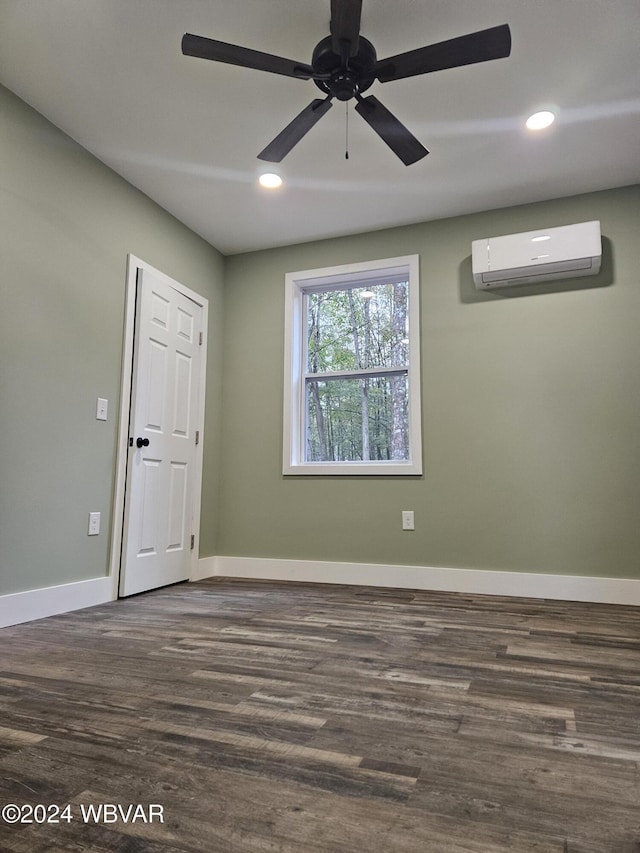 unfurnished room with a wall mounted AC, ceiling fan, and dark hardwood / wood-style flooring