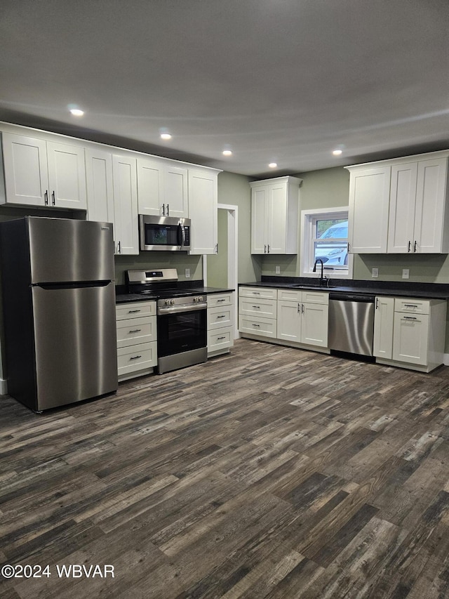 kitchen with dark hardwood / wood-style floors, sink, white cabinetry, and stainless steel appliances