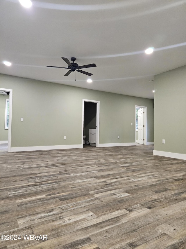 empty room with hardwood / wood-style floors, ceiling fan, and a healthy amount of sunlight