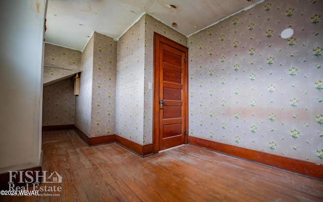 additional living space featuring wood-type flooring and lofted ceiling