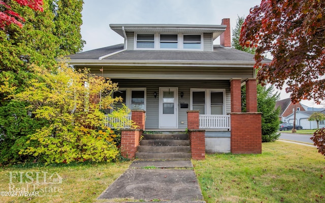 view of front facade featuring covered porch and a front lawn