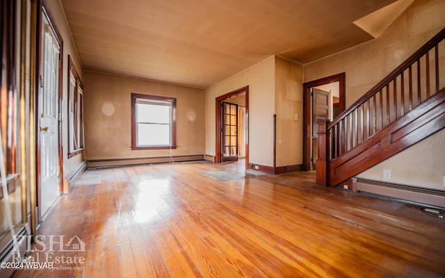 unfurnished living room featuring hardwood / wood-style floors and a baseboard radiator