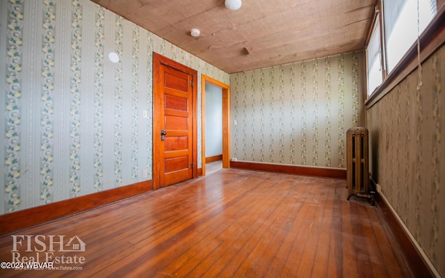 spare room with hardwood / wood-style flooring and radiator