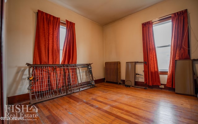 spare room with radiator heating unit and hardwood / wood-style flooring