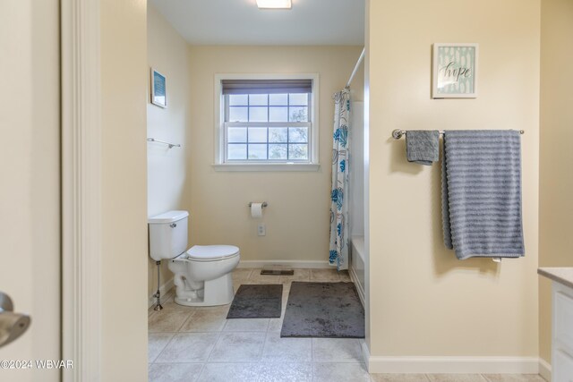 full bathroom featuring tile patterned floors, vanity, toilet, and shower / bath combo with shower curtain