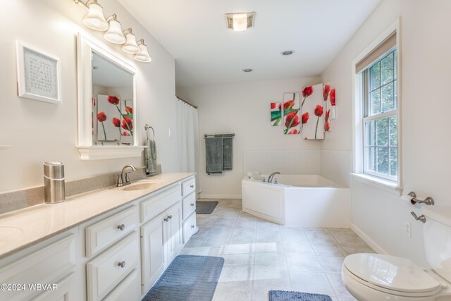 bathroom featuring tile patterned floors, vanity, toilet, and a bathing tub