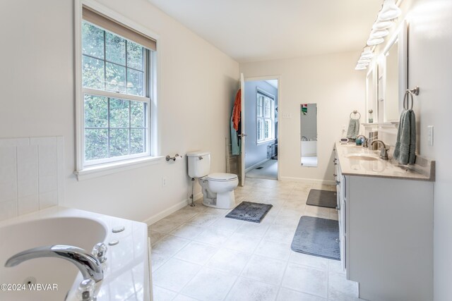 bathroom with tile patterned floors, vanity, toilet, and a bath