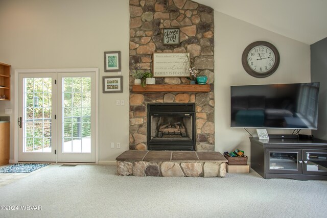 living room with carpet flooring, a stone fireplace, and lofted ceiling