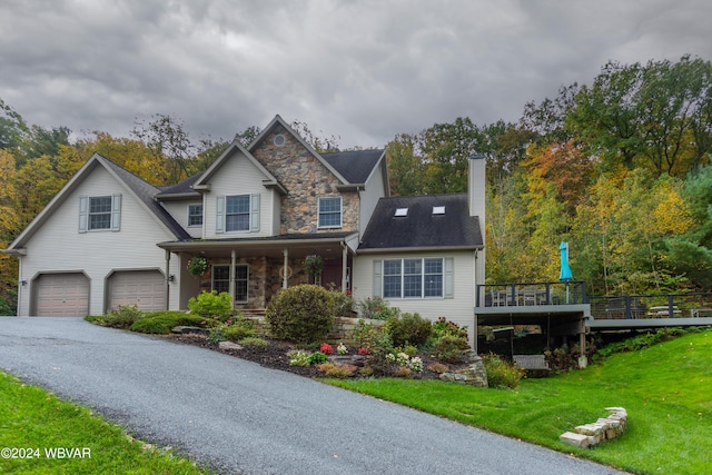 view of front of house with a front yard, a deck, and a garage