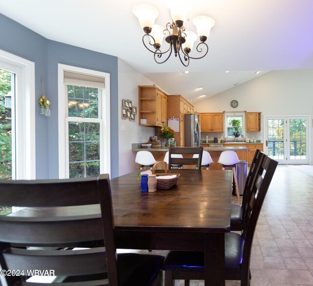 dining space featuring a healthy amount of sunlight, lofted ceiling, and a chandelier