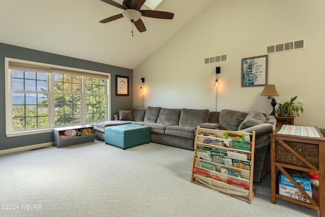 carpeted living room with ceiling fan and high vaulted ceiling