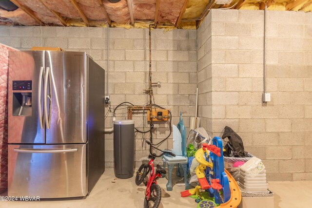 basement featuring stainless steel fridge with ice dispenser