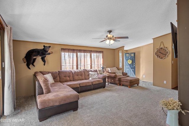 living room featuring carpet floors, ceiling fan, and a textured ceiling