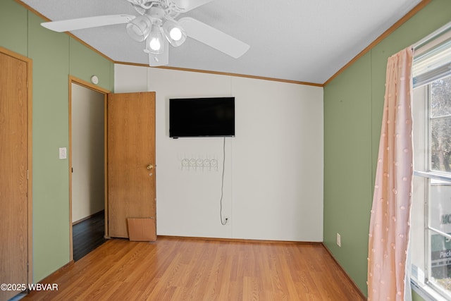 unfurnished room featuring crown molding, ceiling fan, wood finished floors, and lofted ceiling