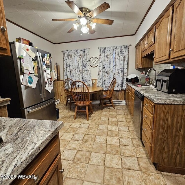 kitchen with a sink, ceiling fan, stainless steel appliances, decorative backsplash, and stone finish flooring