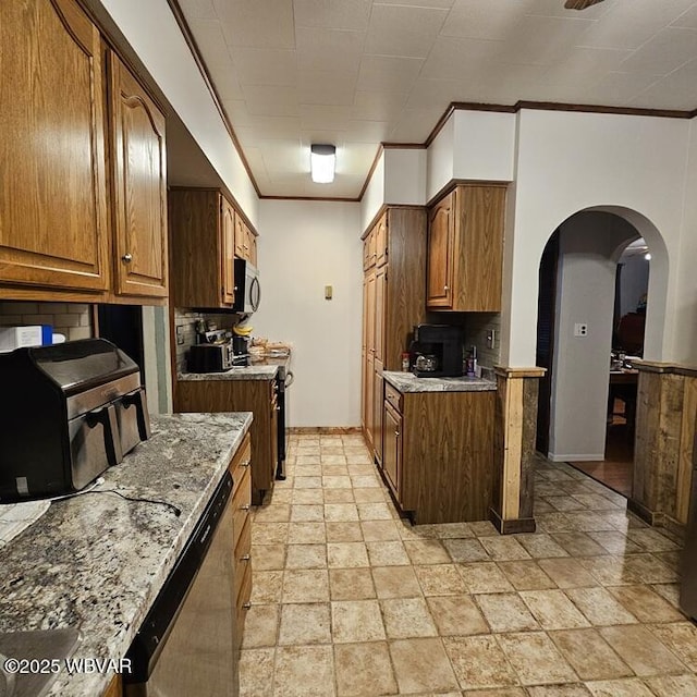 kitchen with tasteful backsplash, baseboards, ornamental molding, stainless steel appliances, and arched walkways