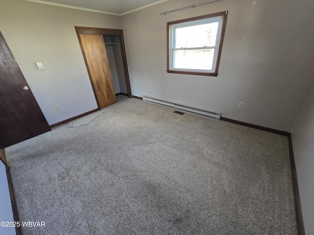 unfurnished bedroom featuring a baseboard heating unit, a closet, crown molding, and carpet floors