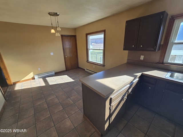 kitchen featuring a baseboard heating unit, dark tile patterned flooring, kitchen peninsula, and decorative light fixtures