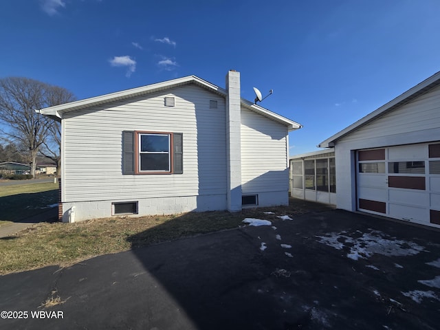 view of property exterior with a garage and a sunroom