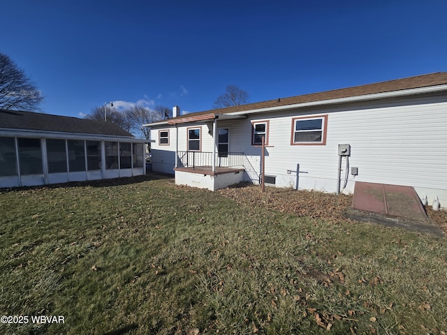 back of property featuring a sunroom and a lawn