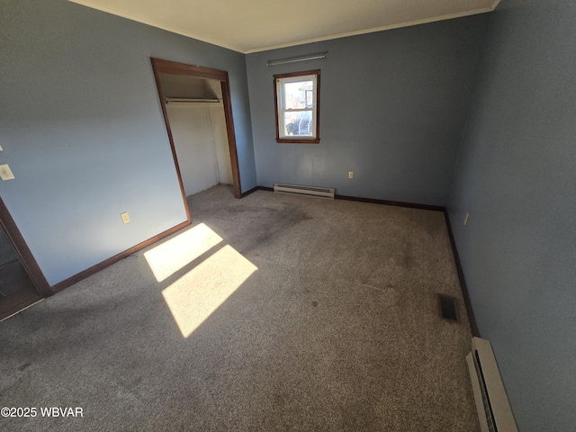 unfurnished bedroom with carpet floors, baseboard heating, and a closet