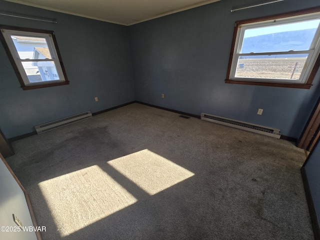 carpeted empty room with a baseboard heating unit and a healthy amount of sunlight