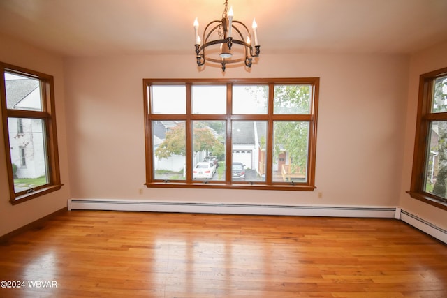 empty room with a baseboard heating unit, light hardwood / wood-style floors, and a notable chandelier