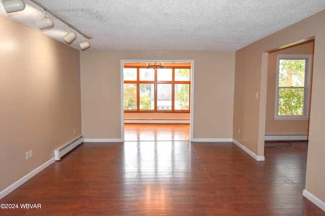 unfurnished room with wood-type flooring, a textured ceiling, and a baseboard heating unit